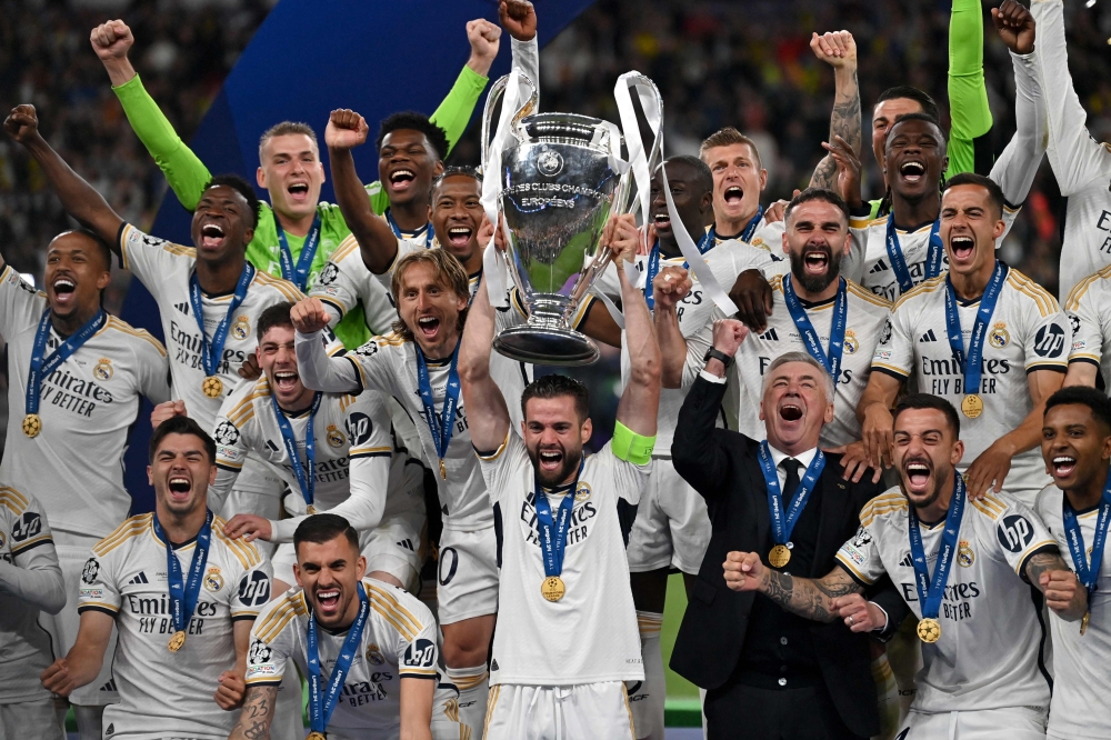 Real Madrid's Spanish defender #06 Nacho Fernandez and Real Madrid's players lift the trophy to celebrate their victory at the end of the UEFA Champions League final football match between Borussia Dortmund and Real Madrid, at Wembley stadium, in London, on June 1, 2024. Photo by Glyn KIRK / AFP.