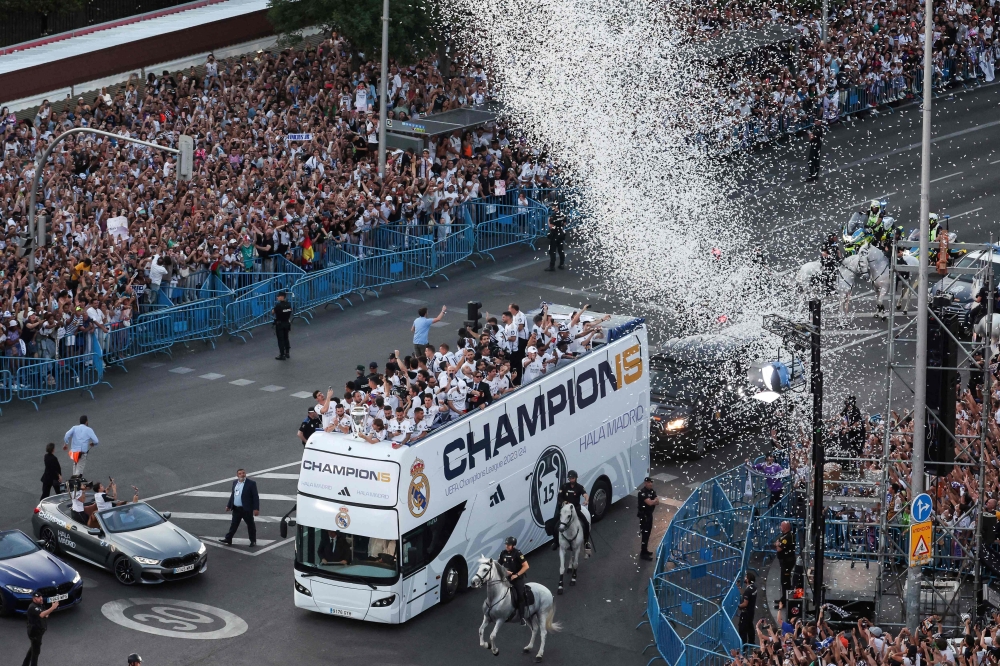 Real Madrid's players parade on their bus on Cibeles square to celebrate their 15th Champions League trophy, one day after beating Borussia Dortmund in London, in Madrid on June 2, 2024. (Photo by Pierre-Philippe Marcou / AFP)

