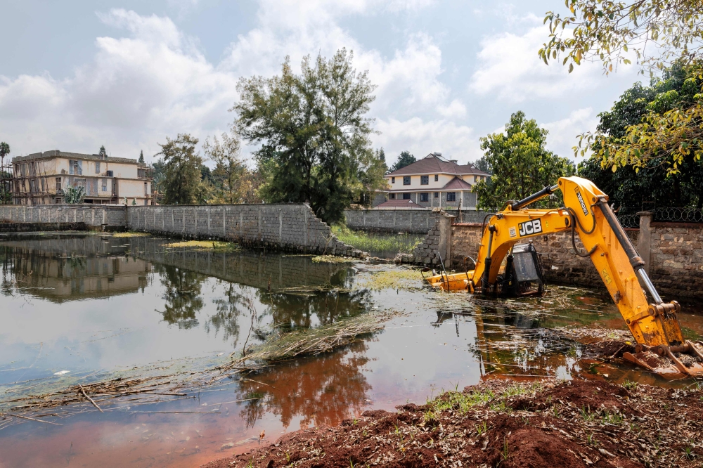 An excavator is marooned in flood water near homes that have been abandoned by their owners at Nairobi's plush Runda estate following recent heavy rainfall in Nairobi on June 05, 2024. (Photo by Tony Karumba / AFP)
