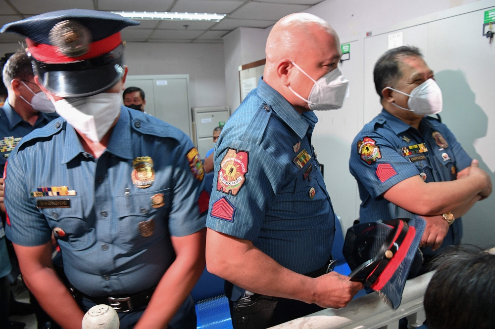 Philippine police officers attend their trial in Manila on June 18, 2024 at a court where they were found guilty of killing a father and son. (Photo by Ted Aljibe / AFP)