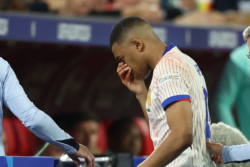 France's forward #10 Kylian Mbappe leaves the pitch after being injured during the UEFA Euro 2024 Group D football match between Austria and France at the Duesseldorf Arena in Duesseldorf on June 17, 2024. Photo by FRANCK FIFE / AFP.