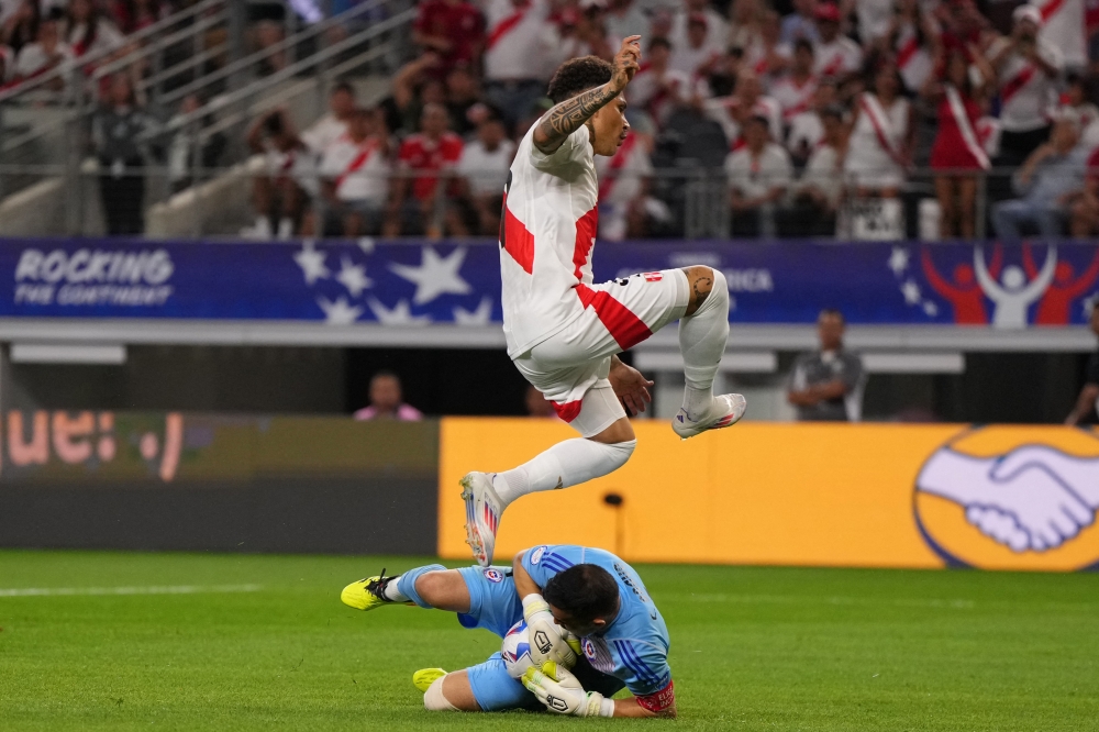 Paolo Guerrero of Peru jumps over Claudio Bravo of Chile as he saves the ball during the CONMEBOL Copa America 2024 Group A match between Peru and Chile at AT&T Stadium on June 21, 2024 in Arlington, Texas. (Photo by Sam Hodde / GETTY IMAGES NORTH AMERICA / Getty Images via AFP)
