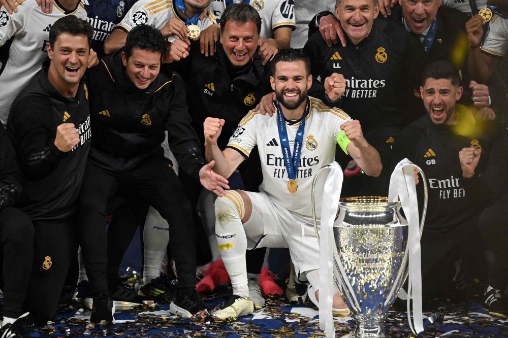 (Files) Real Madrid's Spanish defender #06 Nacho Fernandez celebrates with the trophy after winning the UEFA Champions League final football match on June 1, 2024. (Photo by Paul Ellis / AFP)