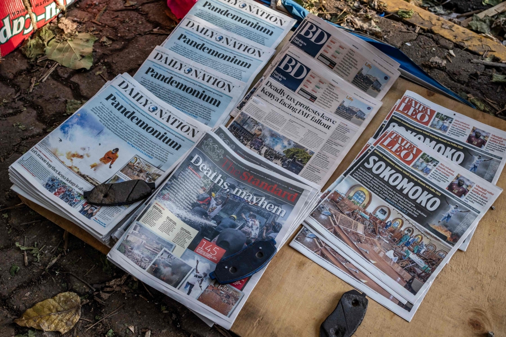 Newspapers are seen displayed on the floor of a small newspaper stall following a deadly nationwide strike to protest against tax hikes and the Finance Bill 2024 in downtown Nairobi, on June 26, 2024. (Photo by Luis Tato / AFP)