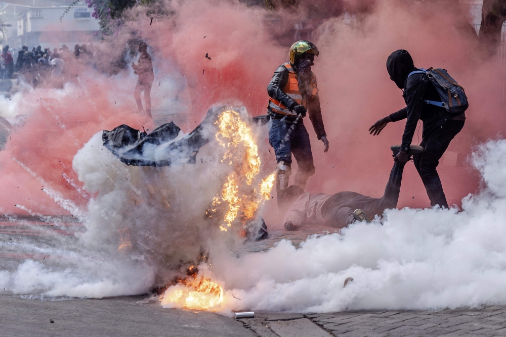File: A tear gas canister explodes as protesters try to help injured people outside the Kenya Parliament during a nationwide strike to protest against tax hikes and the Finance Bill 2024 in downtown Nairobi, on June 25, 2024. (Photo by Luis Tato / AFP)