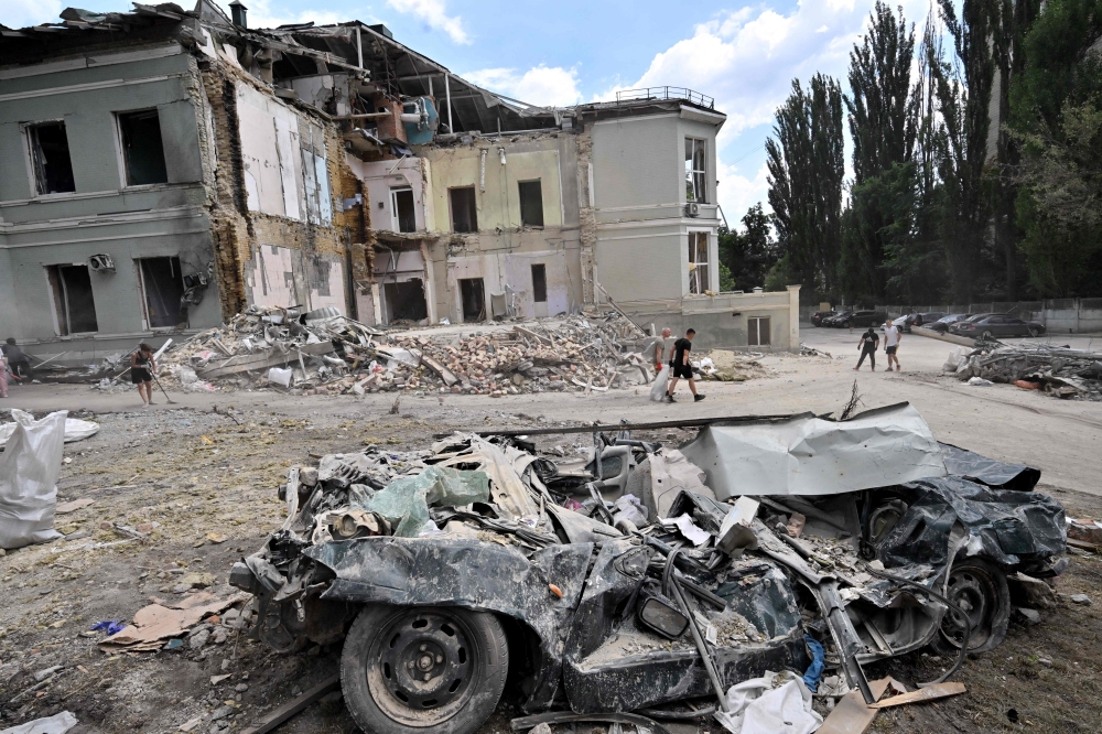 Volunteers carry a sack with debris in Okhmatdyt, the biggest children's hospital in Ukraine, in Kyiv on July 12, 2024, amid Russian invasion in Ukraine. (Photo by Sergei SUPINSKY / AFP)
