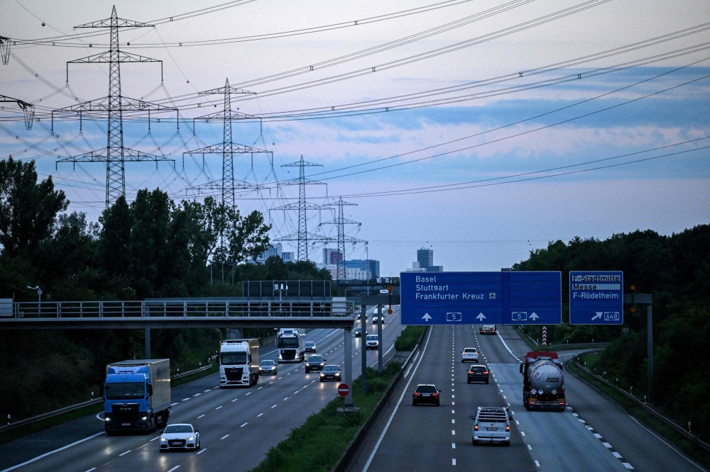 Vehicles drive on A5 motorway during sunset outside Frankfurt am Main, western Germany, on July 8, 2024. (Photo by Kirill Kudryavtsev / AFP)  