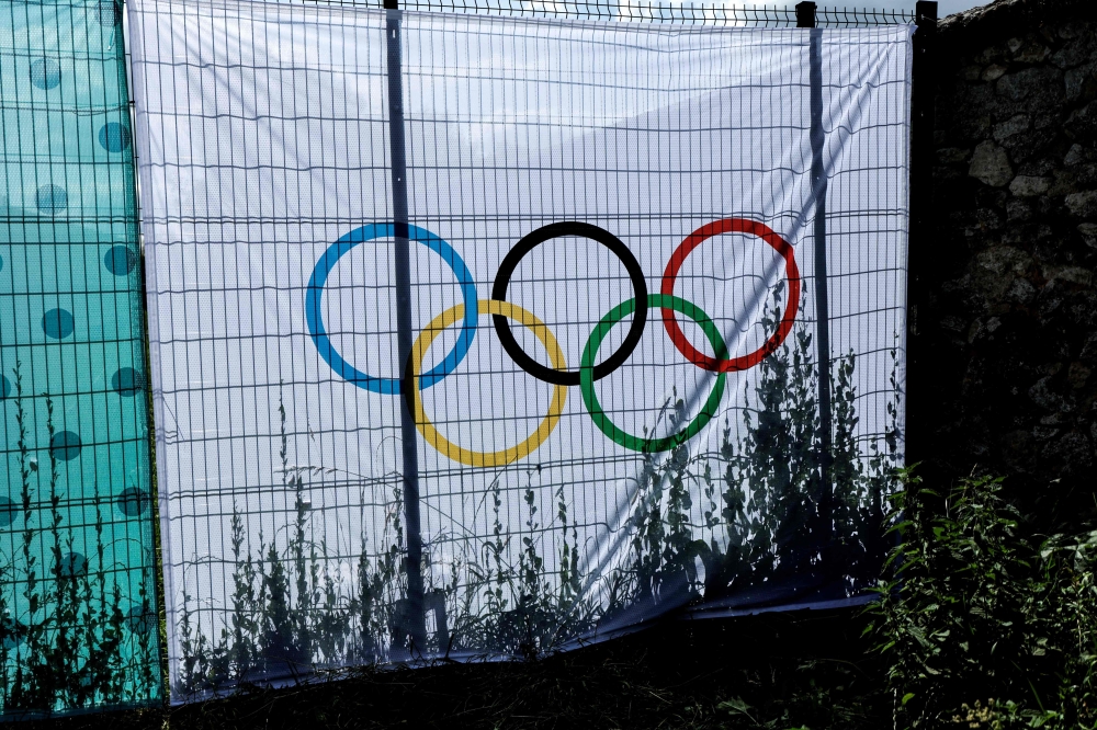 This photograph shows a banner with a sign of Olympic rings on a fence at the Chateau de Versailles, an Olympic venue for the Equestrian and modern Pentathlon, in Versailles, on July 17, 2024, ahead of the Paris 2024 Olympic Games. (Photo by STEPHANE DE SAKUTIN / AFP)