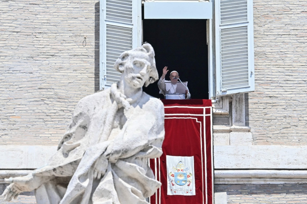 Pope Francis delivers his blessing during the Angelus prayer from the window of the Apostolic Palace overlooking St. Peter's Square, during the Angelus prayer at the Vatican on July 21, 2024. (Photo by Filippo MONTEFORTE / AFP)
