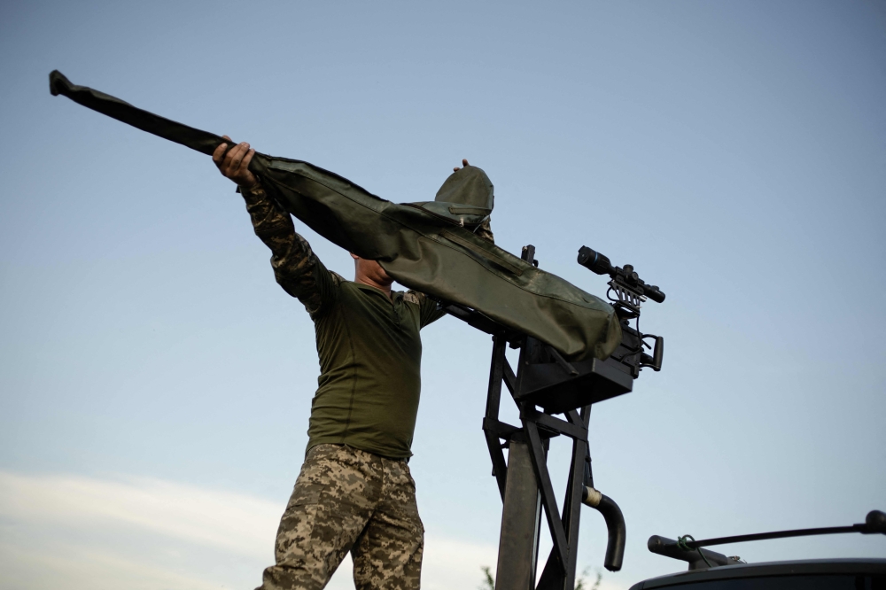 A soldier of a mobile anti-aircrafts brigade prepares a 12.7mm calibre heavy machine gun near a training field in the Khmelnytsky region, on July 8, 2024. (Photo by Florent VERGNES / AFP)
