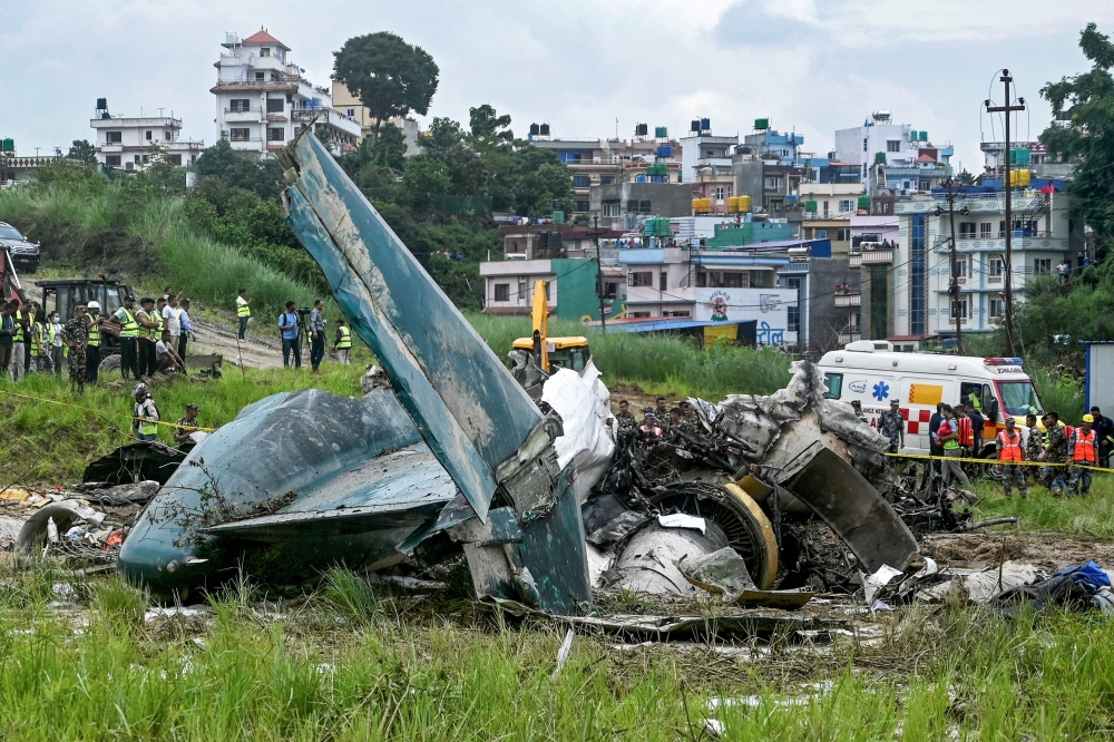 Security personnel inspect the remains of a Saurya Airlines flight after it crashed during takeoff at Tribhuvan International Airport in Kathmandu on July 24, 2024. Photo by PRAKASH MATHEMA / AFP