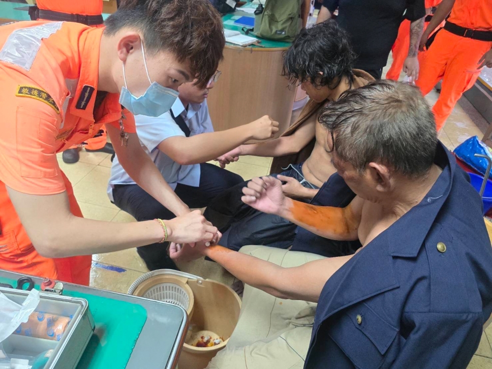 This handout picture taken on July 25, 2024 and released on July 26 by the Taiwan Coast Guard shows two Myanmar sailors being taken cared of by Taiwanese Coast Guard after their Tanzania-flagged ship sank near Kaohsiung during Typhoon Gaemi. Photo by Handout / TAIWAN COAST GUARD / AFP