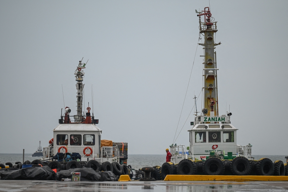 This photo shows tugboats moored as personnel prepare to deploy oil spill equipment, at a port in Limay, Bataan on July 26, 2024. (Photo by Jam Sta Rosa / AFP)