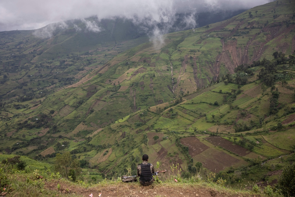 An Ethiopian soldier sits looking at the valley close to the scene of a landslide in Kencho Shacha Gozdi on July 26, 2024. (Photo by Michele Spatari / AFP)