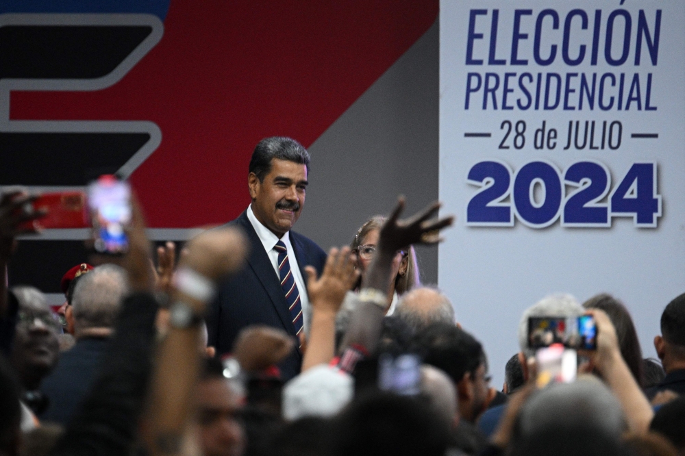 Venezuelan President Nicolas Maduro (L), accompanied by his wife Cilia Flores, attends his proclamation at the National Electoral Council (CNE) headquarters in Caracas on July 29, 2024, a day after the Venezuelan presidential election. (Photo by Federico PARRA / AFP)
