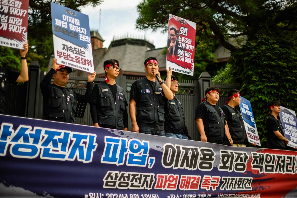 Members of the National Samsung Electronics Union (NSEU) gather during a protest outside the residence of Samsung Electronics Chairman Lee Jae-yong, while holding red placards of Lee that red 
