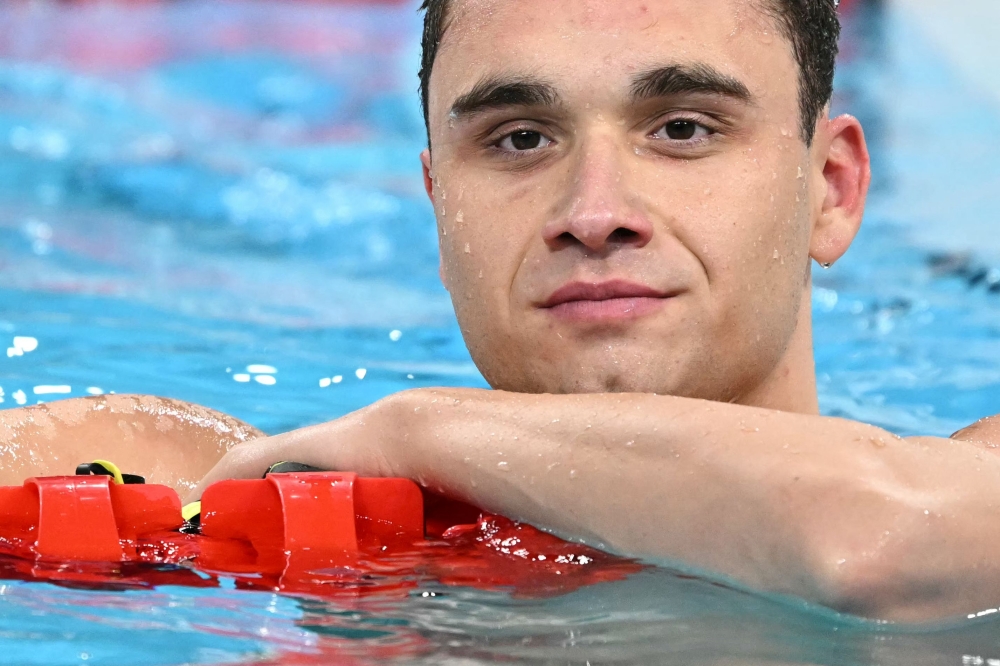 Hungary's Kristof Milak celebrates after winning the final of the men's 100m butterfly swimming event during the Paris 2024 Olympic Games at the Paris La Defense Arena in Nanterre, west of Paris, on August 3, 2024. (Photo by Jonathan NACKSTRAND / AFP)