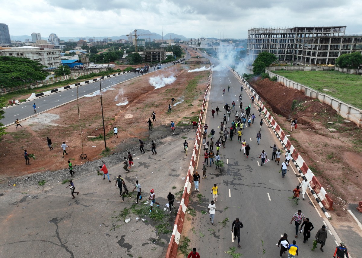 This aerial view shows protestors runing from clouds of tear gas fired by Nigerian security forces during the End Bad Governance protest in Abuja on August 2, 2024. Photo by Kola Sulaimon / AFP