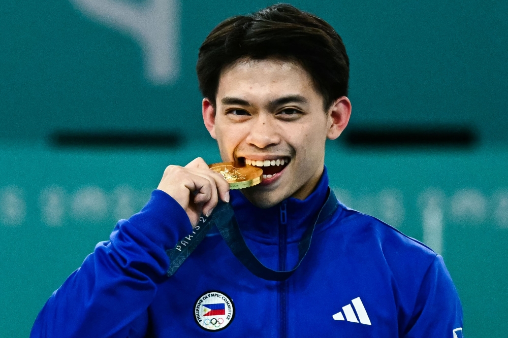 Philippines' Carlos Edriel Yulo (gold) poses during the podium ceremony for the artistic gymnastics men's vault event of the Paris 2024 Olympic Games at the Bercy Arena in Paris, on August 4, 2024. (Photo by Loic VENANCE / AFP)