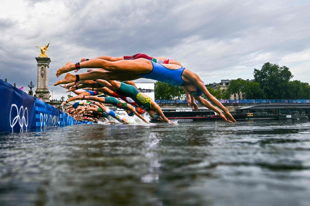 File: Athletes compete in the swimming race in the Seine during the women's individual triathlon at the Paris 2024 Olympic Games in central Paris on July 31, 2024. (Photo by Martin Bureau / POOL / AFP)
