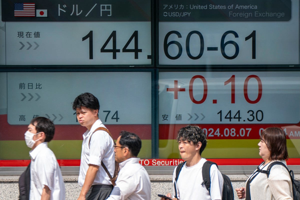 People walk past an electronic quotation board displaying the exchange rate for the Japanese yen against the US dollar in Tokyo on August 7, 2024. Photo by Kazuhiro NOGI / AFP.