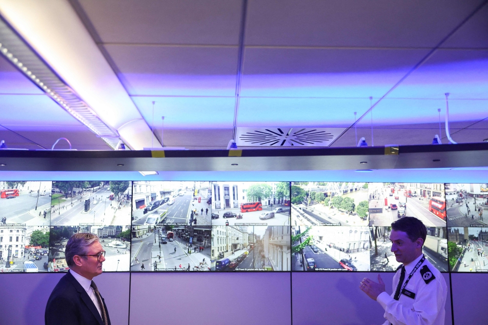 Britain's Prime Minister Keir Starmer (L) speaks with Commander Ben Russell besides CCTV screens in the Engineering Suite in the Metropolitan Police Command and Control Special Operations Room at Lambeth Police Headquarters in London on August 9, 2024. Photo by Toby Melville / POOL / AFP