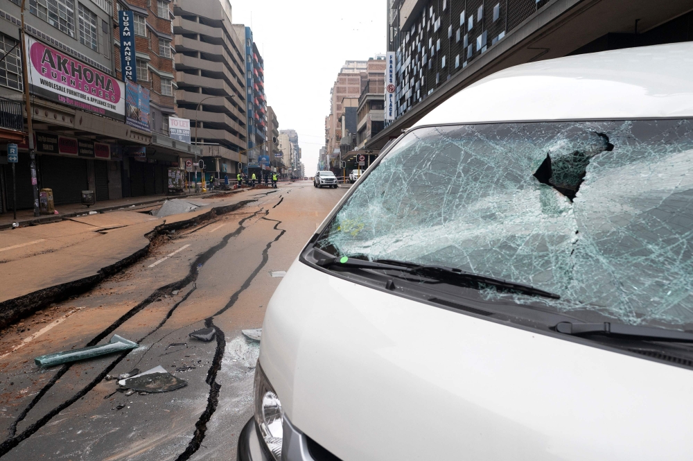 (FILES) A general view of a damaged road in Johannesburg on July 20, 2023, following an unexplained explosion which occurred during rush hour on July 19, 2023. (Photo by Luca Sola / AFP)


