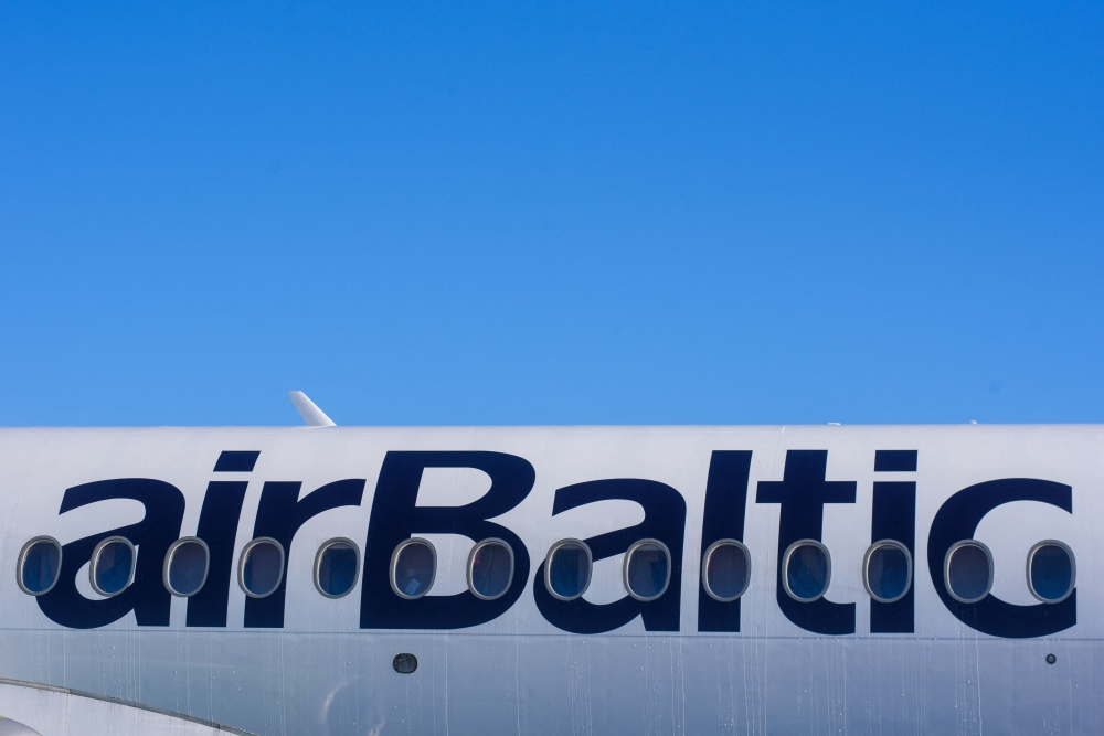 This general view shows the logo on the fuselage of an airBaltic aircraft at Riga International Airport in Riga on April 10, 2020, Latvian airline airBaltic, the largest client in Europe for the Airbus A220-300, has ordered another 10 of the jets, the manufacturer said August 13, 2024. Photo by Gints Ivuskans / AFP