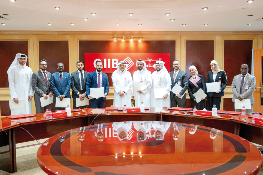 QIIB Chief Executive Officer Dr Abdulbasit Ahmed al Shaibei along with other officials honoring outstanding employees.