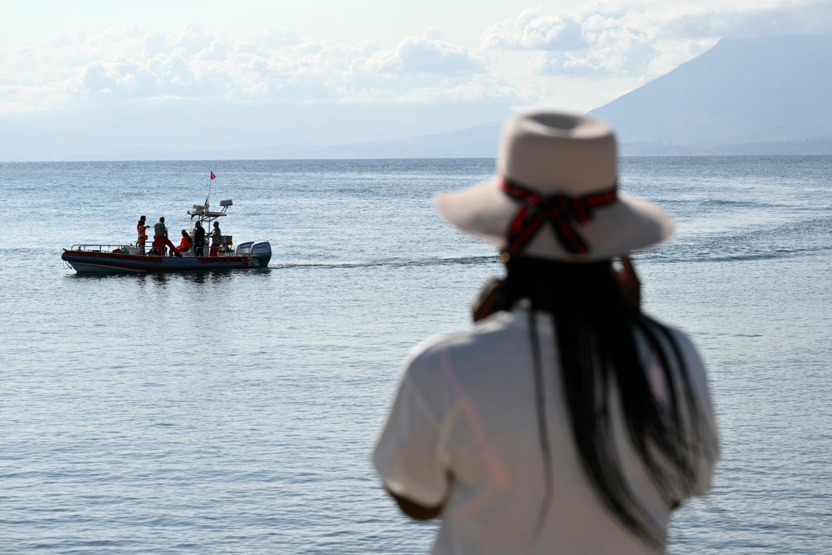A woman watches rescue teams at work in Porticello near Palermo, on August 21, 2024 two days after the British-flagged luxury yacht Bayesian sank. Photo by Alberto PIZZOLI / AFP.