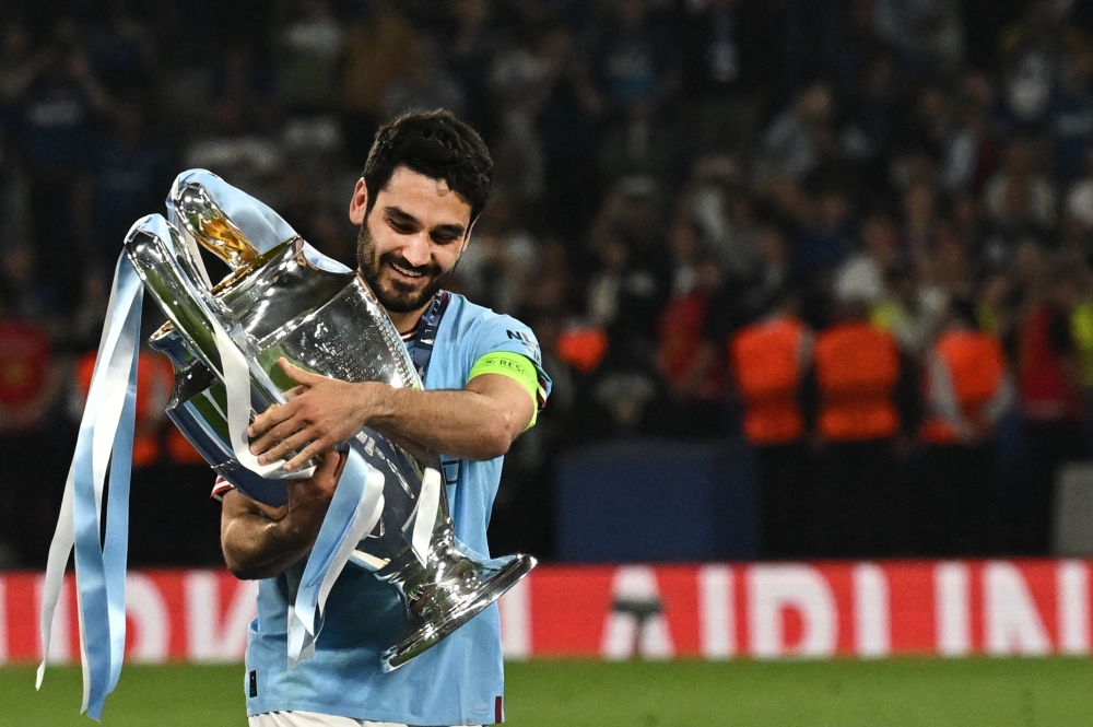 (FILES) Manchester City's German midfielder #8 Ilkay Gundogan poses with the European Cup trophy as they celebrate winning the UEFA Champions League final football match between Inter Milan and Manchester City at the Ataturk Olympic Stadium in Istanbul, on June 10, 2023. (Photo by Paul ELLIS / AFP)

