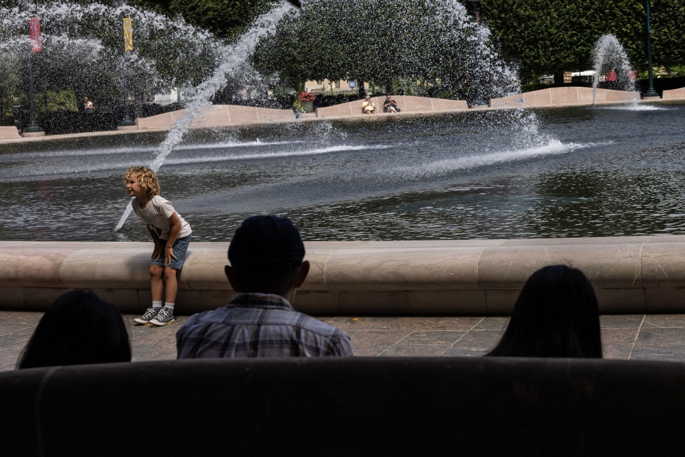A child sits near a fountain at the National Gallery of Art Pavilion Cafe in Washington, DC, on August 20, 2024. (Photo by Anna Rose Layden/Getty Images/AFP)

