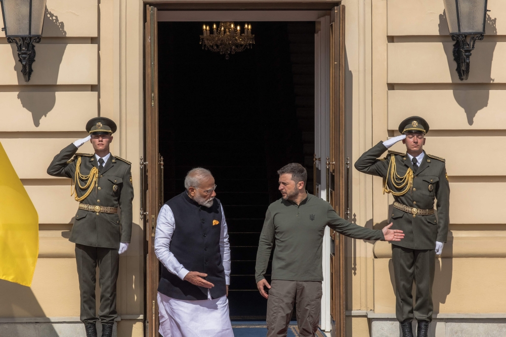 Ukrainian President Volodymyr Zelensky (R) shows the way to Indian Prime Minister Narendra Modi at the entrance of the Mariinskyi Palace during their meeting, on August 23, 2024. (Photo by Roman PILIPEY / AFP)
