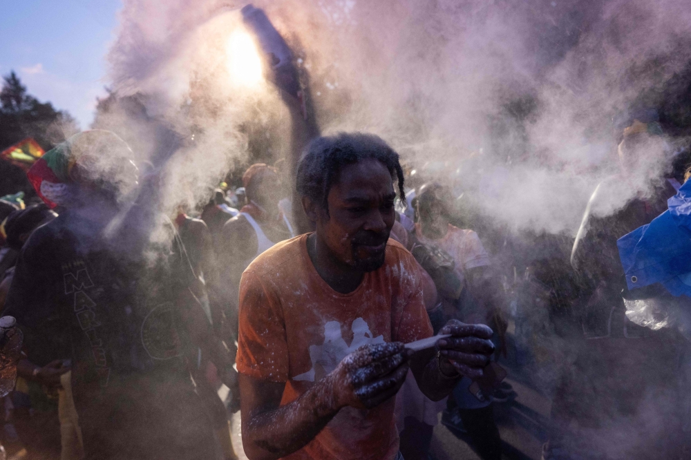 People throw powder as they take part in the annual street party J'ouvert on September 2, 2024 in New York City. (Photo by Adam Gray / GETTY IMAGES NORTH AMERICA / Getty Images via AFP)

