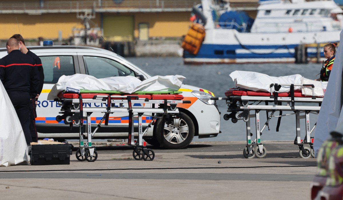 Firefighters and Civil Protection agents stand next to bags containing the bodies of migrants who died after the sinking of a migrant boat attempting to cross the English Channel to England, in Boulogne-sur-Mer, northern France, on September 3, 2024. Photo by Denis Charlet / AFP.