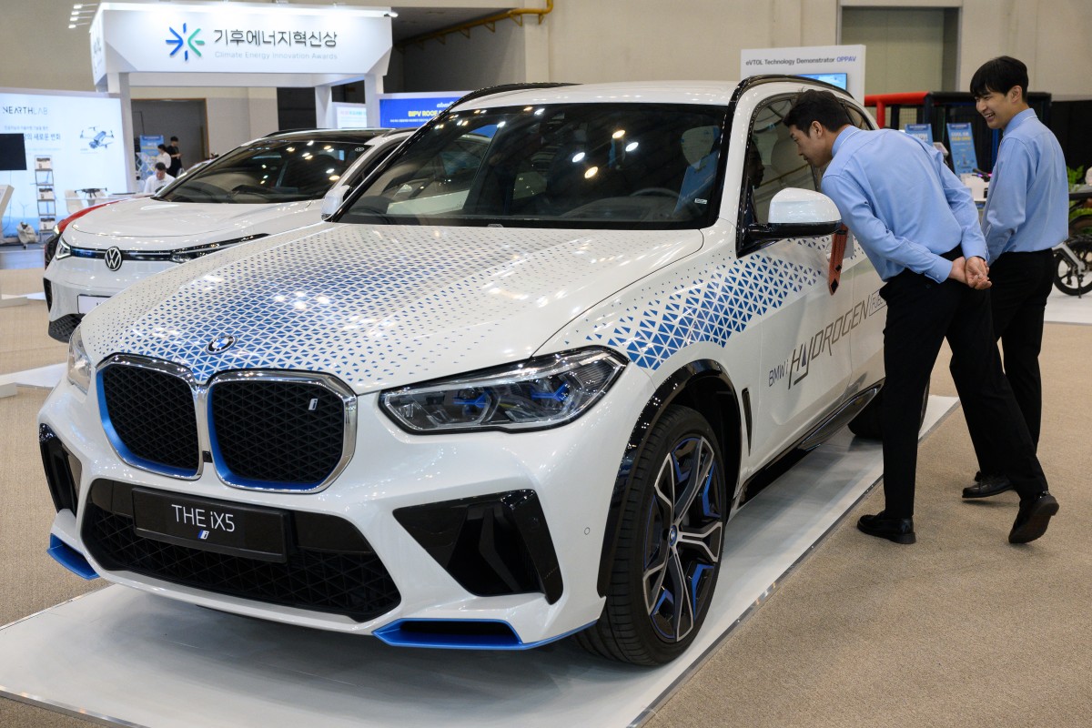 Attendees look at a BMW iX5 Hydrogen Fuel Cell Powered SUV car at the World Climate Industry Expo (2024 WCE) held at BEXCO in Busan on September 4, 2024. (Photo by ANTHONY WALLACE / AFP)