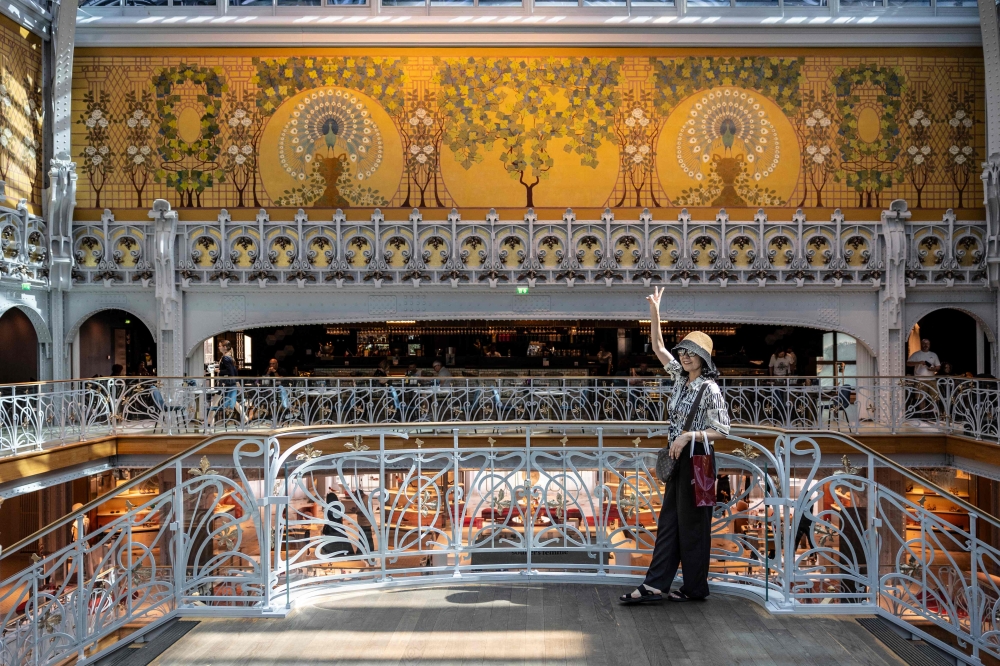 A woman talkes a selfie in La Samaritaine department store, one of the many iconic Paris locations to feature in the hit Netflix series 