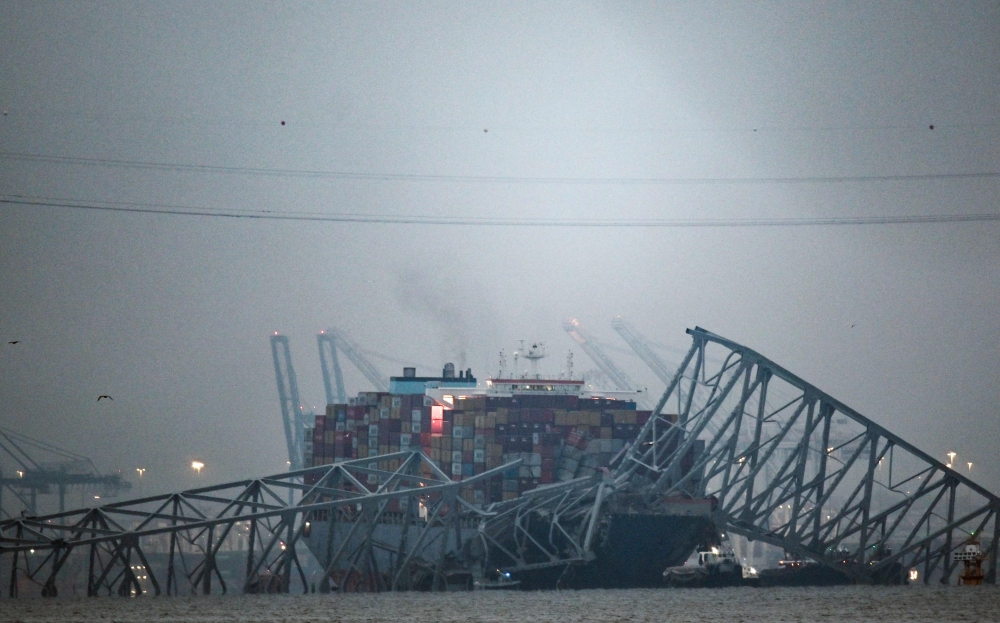 Part of the steel frame of the Francis Scott Key Bridge sits on top of the container ship Dali after the bridge collapsed in Baltimore, Maryland, on March 26, 2024. Photo by Kent Nishimura / AFP

