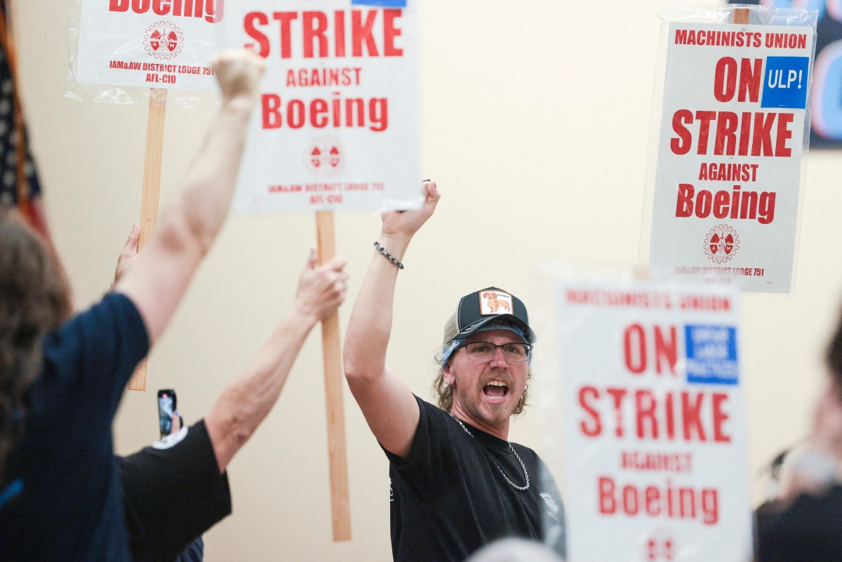 Union members react as Aerospace Machinists District 751 President Jon Holden (out of frame) announces that union members rejected a proposed Boeing contract and will go on strike, following voting results at their union hall in Seattle, Washington, on September 12, 2024. Photo by Jason Redmond / AFP.