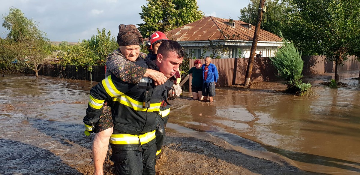 This photo taken on September 14, 2024 and handed out by the Romanian Inspectorate for Emergency Situations shows a rescue worker carrying an elderly women through the floods in Pechea, Galati county, Romania. Photo by Romanian Inspectorate for Emergency Situations / AFP.
