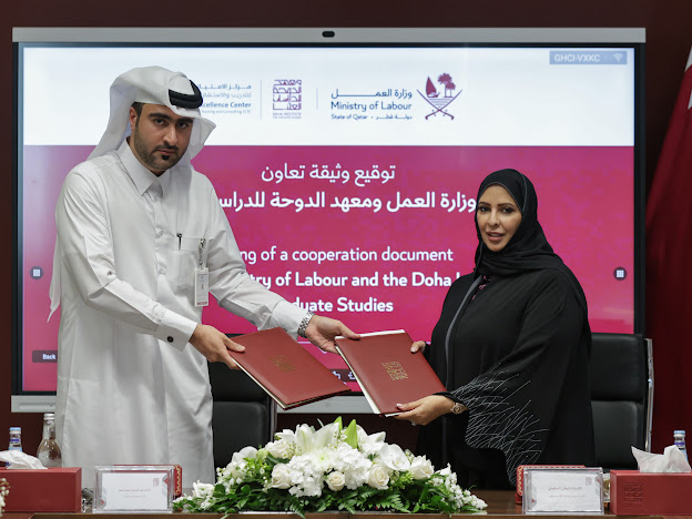 Officials exchanging documents after signing the agreement.