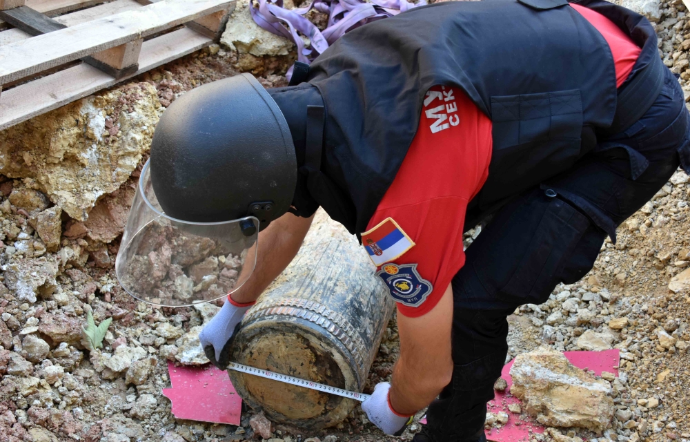 A handout photo distributed on September 22, 2024 by the Ministry of the Interior of Serbia, shows a special police unit officer near an unexploded 300-kilo WWI artillery round at a construction site near the Serbian Parliament in Belgrade. Photo by HANDOUT / Ministry of the Interior of Serbia / AFP