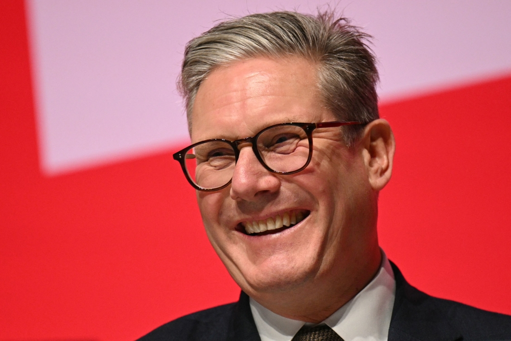 Britain's Prime Minister Keir Starmer smiles on stage on the first full day of the annual Labour Party conference in Liverpool, north-west England, on September 22, 2024. (Photo by Oli SCARFF / AFP)