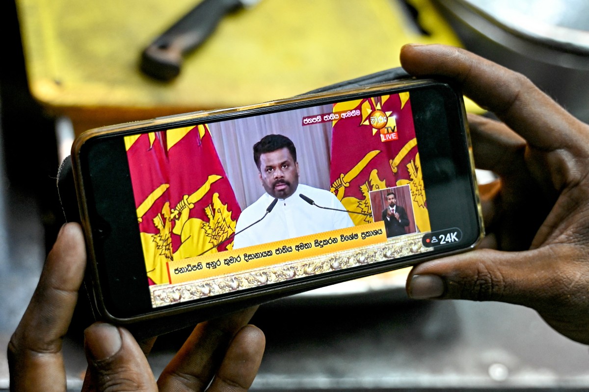 A vendor watches a live telecast as Sri Lanka's newly elected President Anura Kumara Dissanayake addresses the nation, at Galle Face Beach in Colombo on September 25, 2024. (Photo by Idrees MOHAMMED / AFP)
