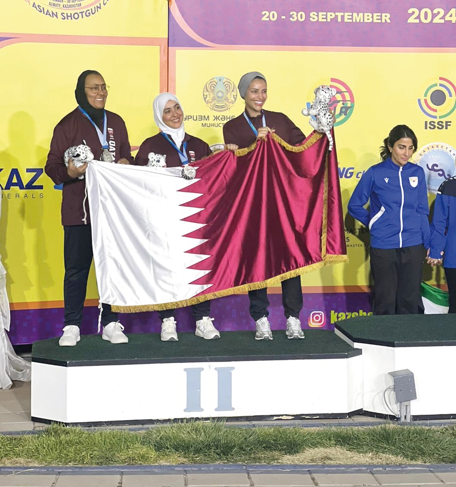 Qatar's Kholoud Al Khalaf, Amna Al Abdullah and Maitha Al Binali celebrate on the podium after winning the  silver medal in women’s trap team category. 