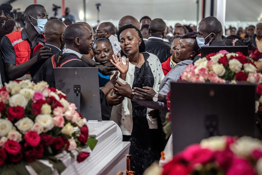 A family member of a deceased student is comforted by relatives and counsellors as she tries to touch a coffin during the memorial service for the 21 Hillside Endarasha Academy school fire victims in Mweiga on September 26, 2024. Photo by LUIS TATO / AFP