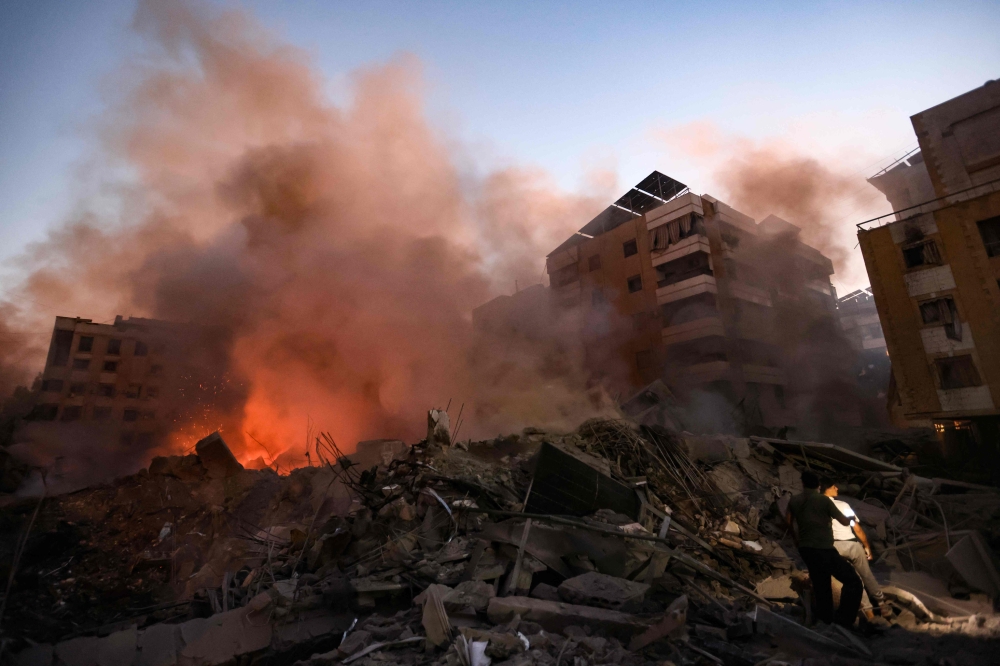 Smoke rises from the smouldering rubble at the scene of Israeli air strikes in the Haret Hreik neighbourhood of Beirut's southern suburbs on September 27, 2024. (Photo by Ibrahim AMRO / AFP)
