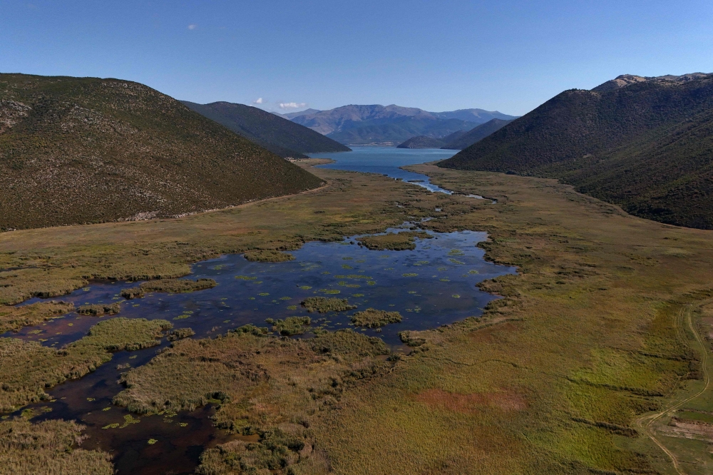 An aerial photo taken on September 12, 2024, shows the Little Prespa Lake, near the village of Buzeliqen. (Photo by Adnan Beci / AFP)
 