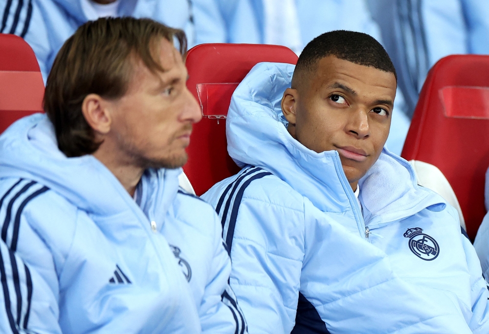 Real Madrid's French forward Kylian Mbappe (R) reacts on the bench during the UEFA Champions League football match between Lille LOSC and Real Madrid at the Pierre Mauroy Stadium in Villeneuve-d'Ascq, northern France, on October 2, 2024 (Photo by FRANCK FIFE / AFP)
