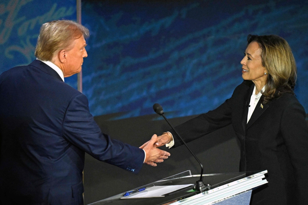 US Vice President and Democratic presidential candidate Kamala Harris (R) shakes hands with former US President and Republican presidential candidate Donald Trump during a presidential debate at the National Constitution Center in Philadelphia, Pennsylvania, on September 10, 2024. (Photo by SAUL LOEB / AFP)

